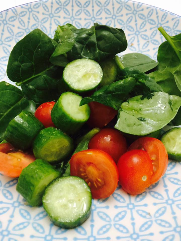 Spinach tomato and cucumber salad with olive oil and smoked salt.